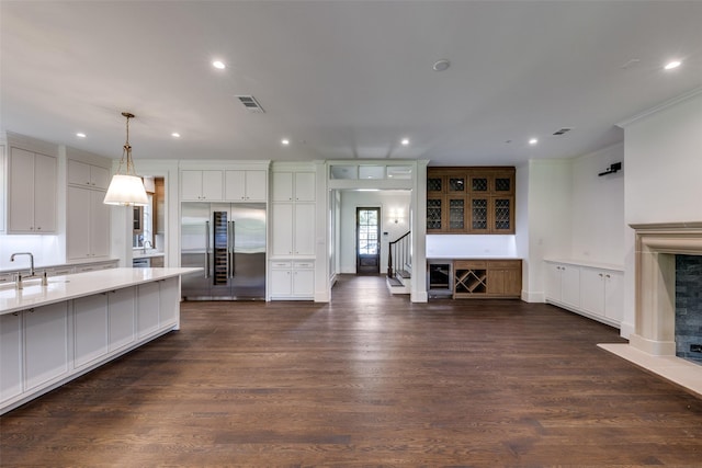 7538 Centenary Ave, Dallas, TX 75225 - kitchen with stainless steel built in refrigerator, light countertops, recessed lighting, dark wood-style floors, and a fireplace