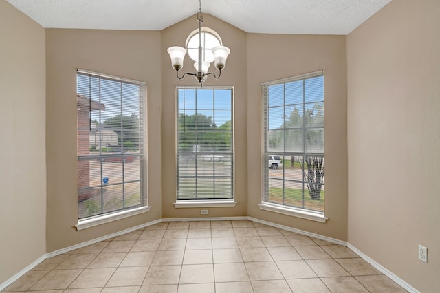 unfurnished dining area featuring baseboards, an inviting chandelier, a healthy amount of sunlight, and lofted ceiling