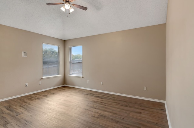 spare room with baseboards, a ceiling fan, a textured ceiling, and wood finished floors