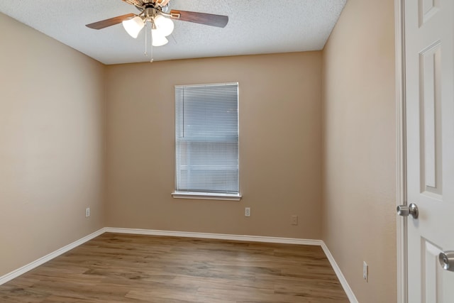 spare room with a textured ceiling, baseboards, a ceiling fan, and wood finished floors