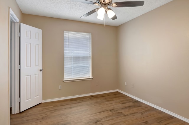 unfurnished bedroom with baseboards, a textured ceiling, ceiling fan, and wood finished floors
