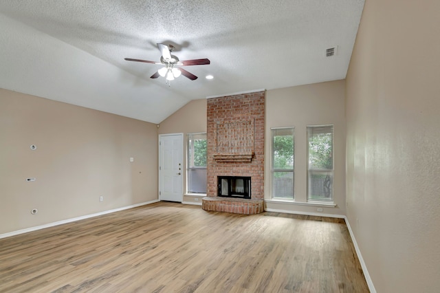 unfurnished living room featuring visible vents, a brick fireplace, baseboards, a ceiling fan, and light wood finished floors