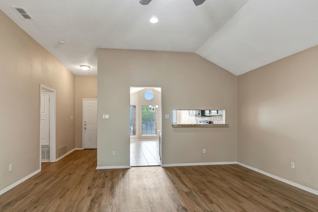 unfurnished room featuring visible vents, lofted ceiling, wood finished floors, baseboards, and a ceiling fan