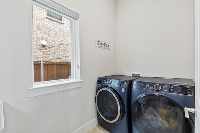 washroom featuring baseboards, laundry area, and washer and dryer