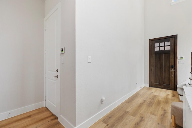 foyer with light wood-type flooring and baseboards