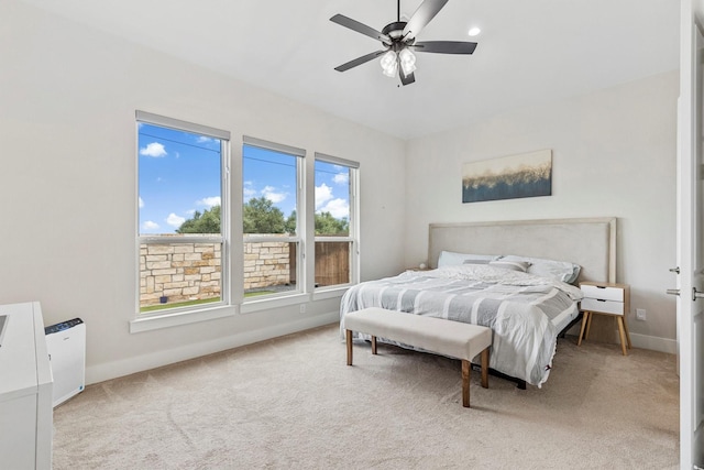 carpeted bedroom featuring baseboards and ceiling fan