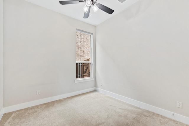 unfurnished room with baseboards, ceiling fan, and light colored carpet