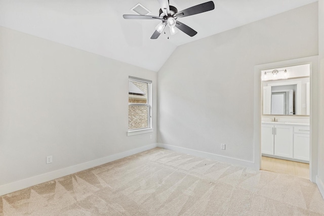 unfurnished bedroom featuring visible vents, a sink, baseboards, lofted ceiling, and carpet flooring