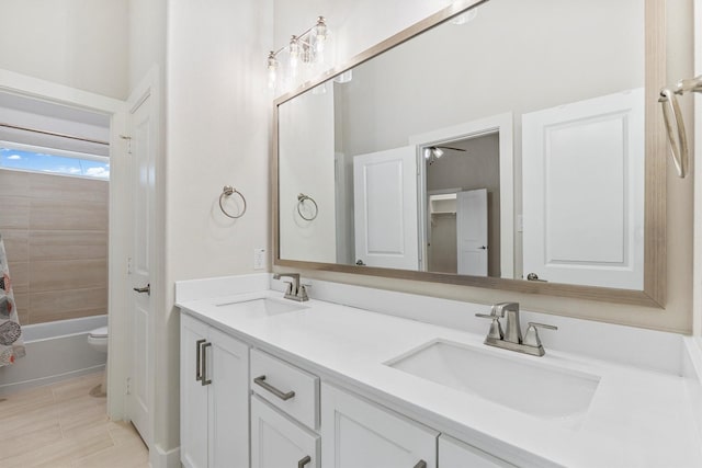 full bathroom with double vanity, toilet, shower / bathtub combination with curtain, and a sink