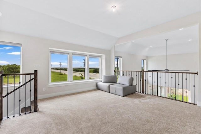 unfurnished room with carpet floors, baseboards, an upstairs landing, and a wealth of natural light