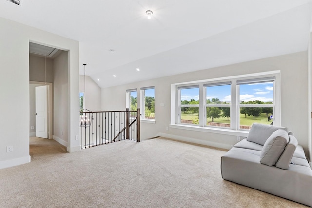 living area with baseboards, attic access, carpet flooring, vaulted ceiling, and an upstairs landing