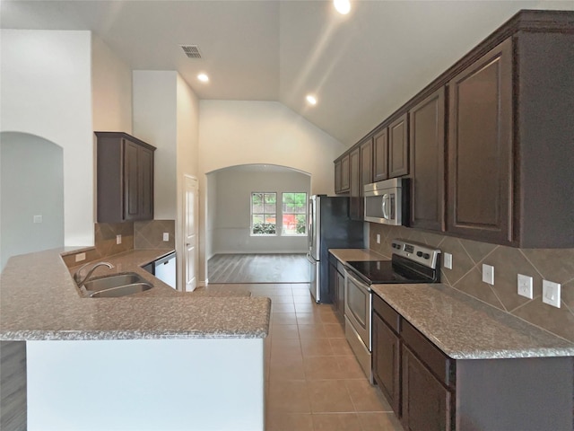 kitchen with a sink, arched walkways, stainless steel appliances, and visible vents