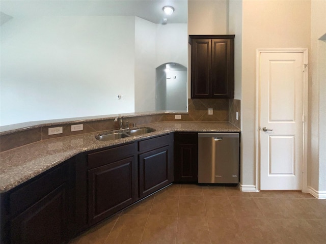 kitchen featuring stainless steel dishwasher, dark brown cabinets, a sink, stone counters, and light tile patterned floors