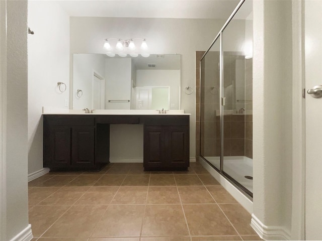 full bath featuring double vanity, a sink, tile patterned flooring, and a stall shower