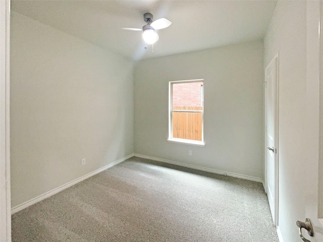 carpeted spare room with baseboards and ceiling fan