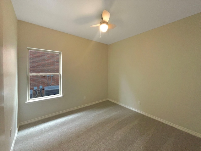 carpeted spare room with baseboards and a ceiling fan