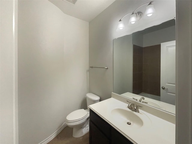 bathroom with vanity, tile patterned flooring, baseboards, and toilet