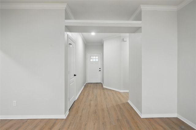 hallway featuring crown molding, baseboards, and wood finished floors