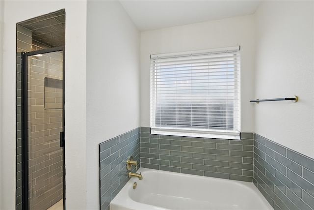 bathroom with a stall shower and a bath