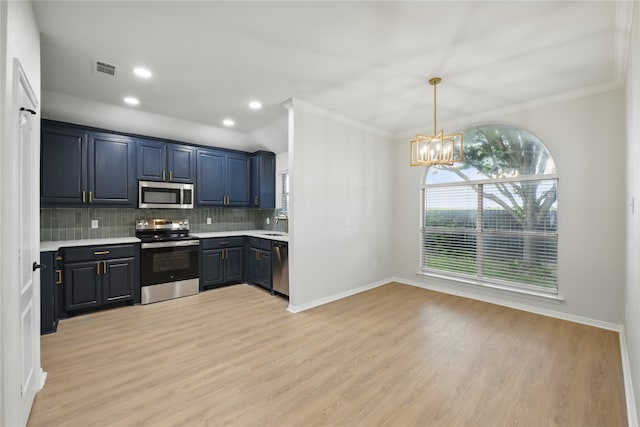 kitchen with light countertops, a chandelier, stainless steel appliances, decorative backsplash, and ornamental molding