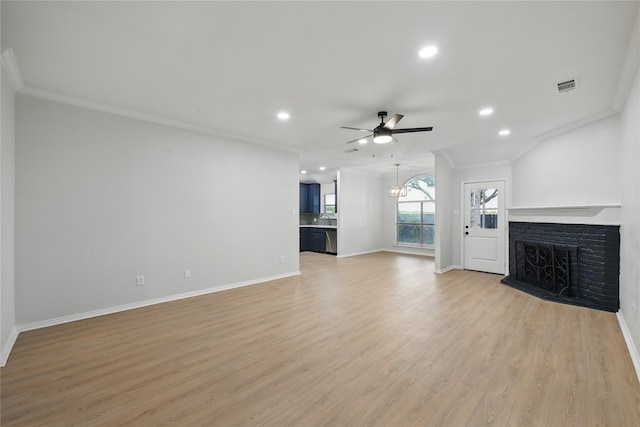 unfurnished living room featuring a fireplace with raised hearth, ceiling fan with notable chandelier, recessed lighting, visible vents, and ornamental molding