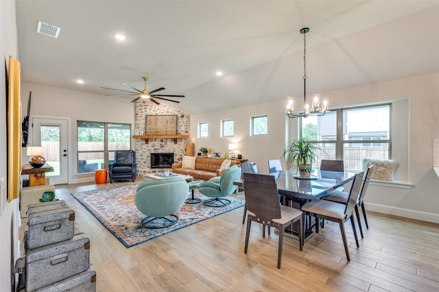 dining area featuring visible vents, a healthy amount of sunlight, ceiling fan with notable chandelier, and a fireplace