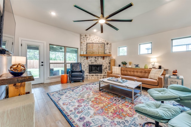 living room featuring light wood-style floors, ceiling fan, lofted ceiling, and a fireplace