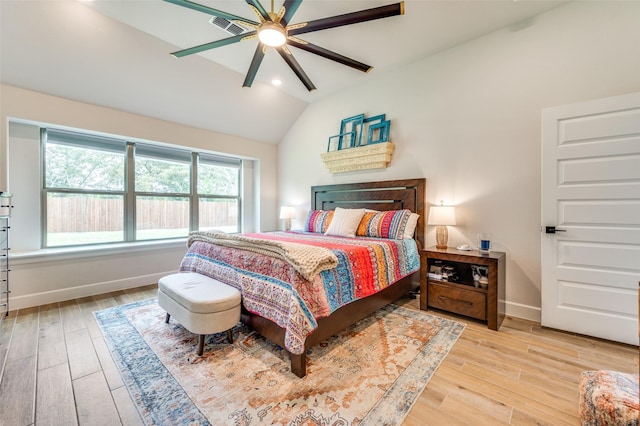 bedroom with baseboards, visible vents, vaulted ceiling, and light wood finished floors
