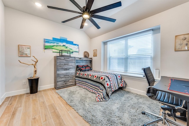 bedroom featuring a ceiling fan, baseboards, vaulted ceiling, and wood finished floors