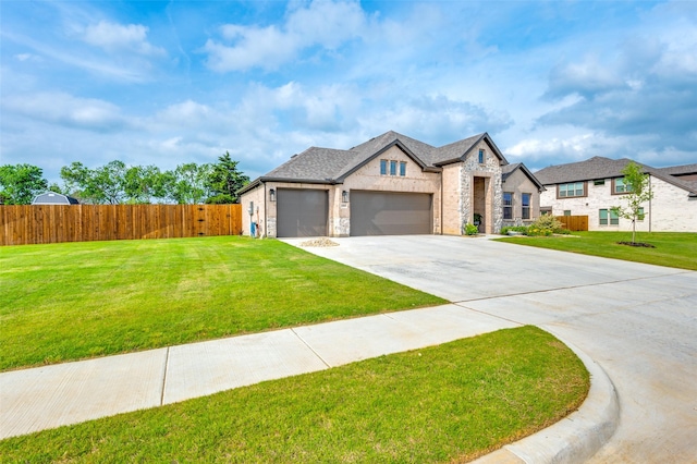 french country style house with an attached garage, fence, driveway, and a front yard