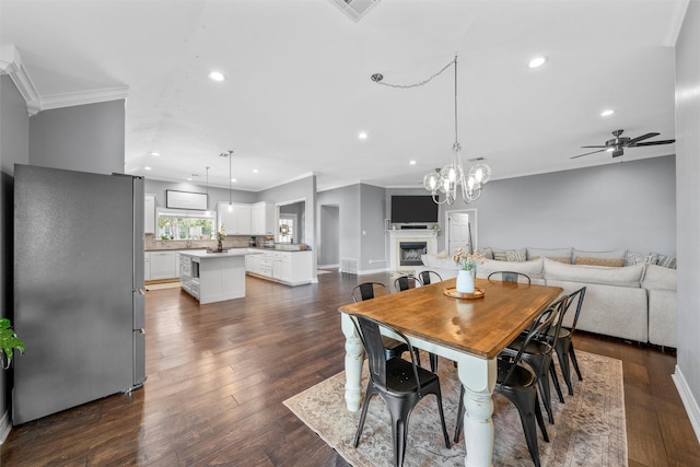 dining space with ornamental molding, dark wood-style flooring, recessed lighting, and ceiling fan
