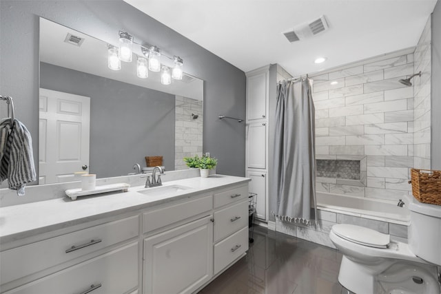 bathroom featuring vanity, tiled shower / bath, toilet, and visible vents