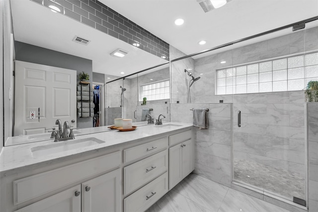 bathroom featuring double vanity, visible vents, a shower stall, a sink, and marble finish floor