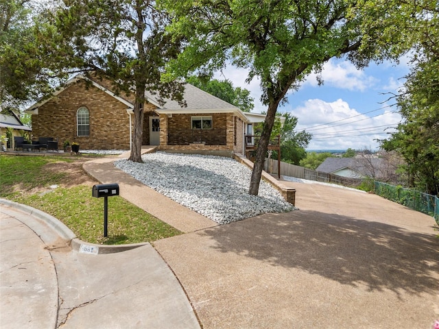 view of front facade with brick siding and fence