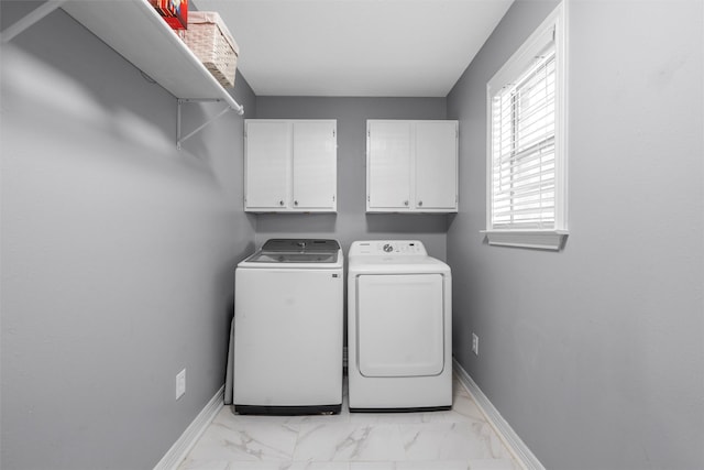 clothes washing area with baseboards, cabinet space, independent washer and dryer, and marble finish floor