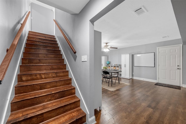 stairway with visible vents, a ceiling fan, baseboards, and wood finished floors