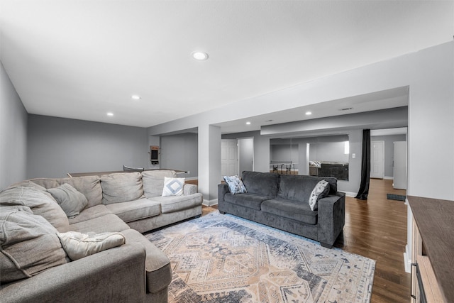 living room featuring recessed lighting, baseboards, and dark wood-type flooring