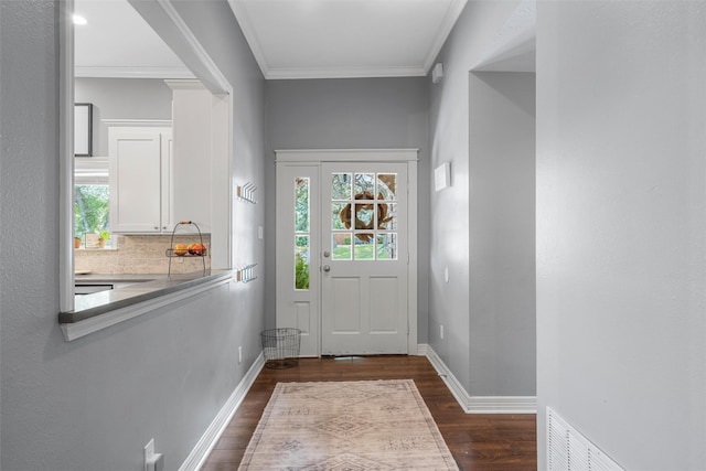 doorway featuring crown molding, baseboards, dark wood finished floors, and visible vents