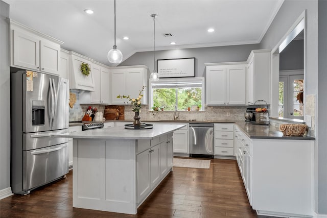 kitchen with a kitchen island, white cabinetry, a sink, backsplash, and stainless steel appliances