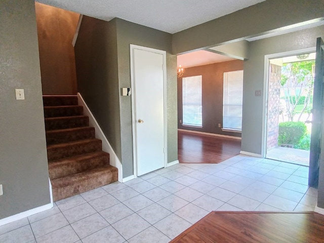 foyer with stairway, baseboards, and light tile patterned flooring