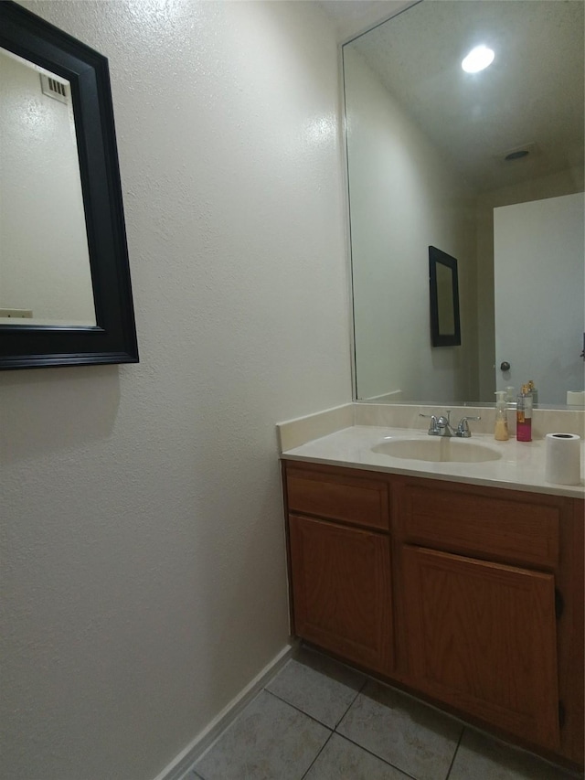 bathroom with tile patterned flooring, baseboards, and vanity