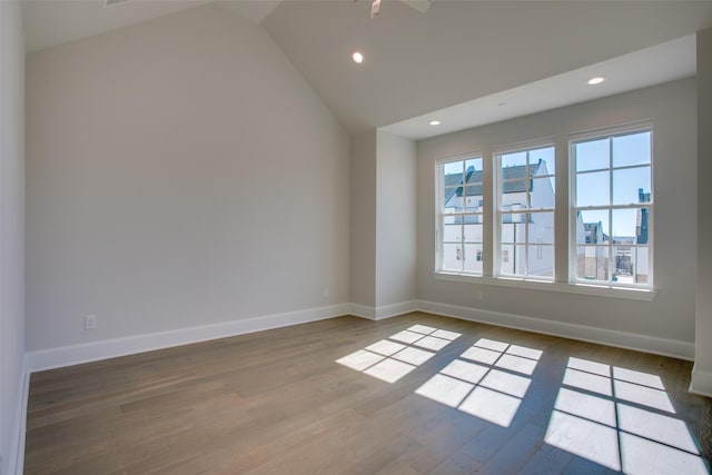 spare room with baseboards, recessed lighting, wood finished floors, and vaulted ceiling