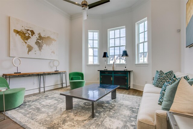 living room with baseboards, ceiling fan, ornamental molding, and wood finished floors