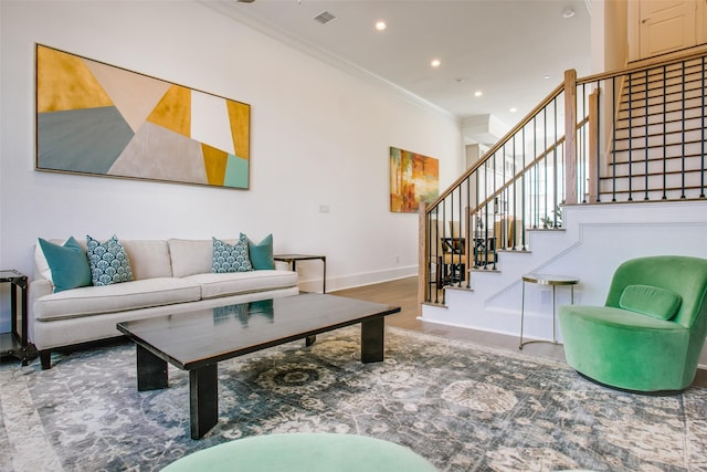 living area featuring crown molding, stairs, baseboards, and visible vents