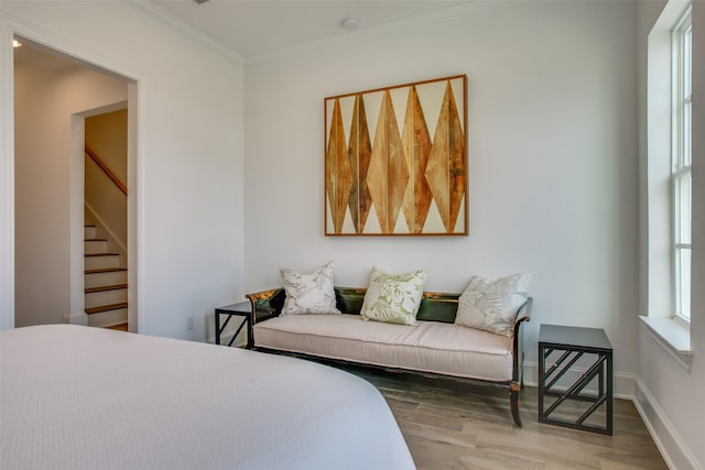 bedroom featuring crown molding, baseboards, and wood finished floors