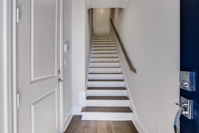 stairway featuring baseboards and wood finished floors