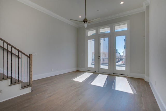 unfurnished living room featuring crown molding, baseboards, a ceiling fan, and wood finished floors
