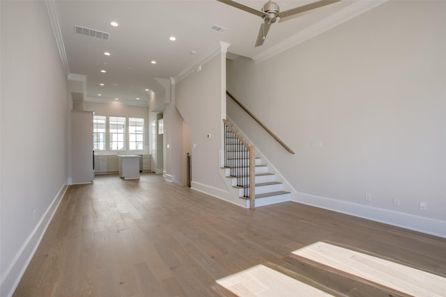unfurnished living room featuring baseboards, ornamental molding, and visible vents
