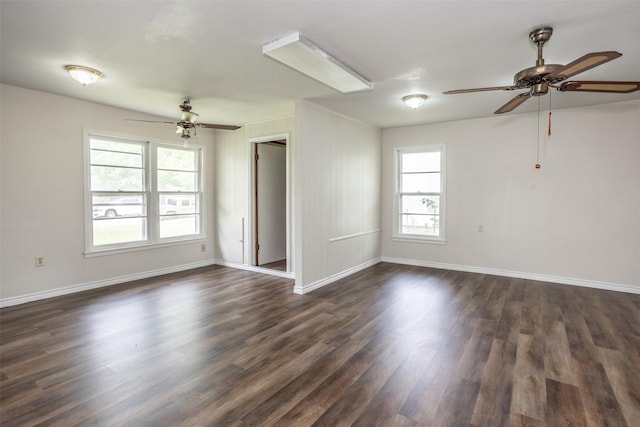 empty room with baseboards, dark wood-style flooring, and ceiling fan