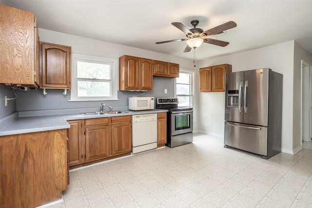 kitchen featuring a sink, light countertops, brown cabinetry, and stainless steel appliances